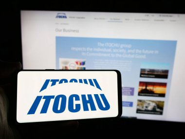 Stuttgart, Germany - 08-08-2024: Person holding smartphone with logo of Japanese company Itochu Corporation in front of website. Focus on phone display. clipart