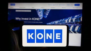 Stuttgart, Almanya - 08-08-2024: İş sayfası önünde Fin asansör mühendisliği şirketi Kone Oyj 'un logosuyla cep telefonu tutan kişi. Telefon ekranına odaklan.