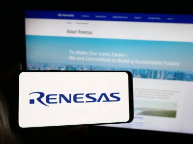 Stuttgart, Almanya - 08-09-2024: Japon şirketi Renesas Electronics Corporation 'ın logosuna sahip akıllı telefon sahibi kişi web sitesi önünde. Telefon ekranına odaklan.