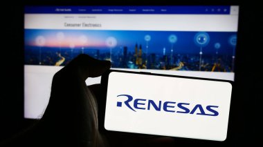 Stuttgart, Almanya - 08-09-2024: Japon firması Renesas Electronics Corporation 'ın logosuyla cep telefonu sahibi kişi iş sayfasının önünde. Telefon ekranına odaklan.