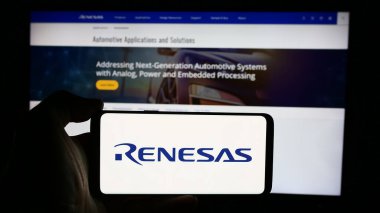 Stuttgart, Almanya - 08-09-2024: Japon firması Renesas Electronics Corporation 'ın logosuyla cep telefonu tutan kişi iş sayfası önünde. Telefon ekranına odaklan.