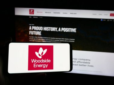 Stuttgart, Almanya - 08-09-2024: Avustralyalı Woodside Energy Group Limited şirketinin logosuna sahip akıllı telefon sahibi kişi web sitesinin önünde. Telefon ekranına odaklan.