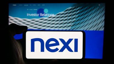 Stuttgart, Almanya - 08-13-2024: İtalyan ödeme sistemleri şirketi Nexi S.P.A. 'nın logosuna sahip akıllı telefon sahibi kişi web sitesinin önünde. Telefon ekranına odaklan.