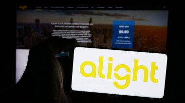 Stuttgart, Almanya - 08-15-2024: İnternet sitesinin önünde ABD 'li sermaye teknolojisi Alight Inc.' in logosuna sahip akıllı telefon sahibi kişi. Telefon ekranına odaklan.