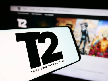 Stuttgart, Germany - 08-15-2024: Smartphone with logo of American gaming company Take-Two Interactive Software Inc. in front of website. Focus on center of phone display. clipart