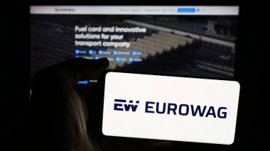 Stuttgart, Almanya - 08-15-2024: Çek W.A.G. şirketinin logosuna sahip cep telefonu sahibi kişi Ödeme çözümleri a.s. (Eurowag) web sayfasının önünde. Telefon ekranına odaklan.