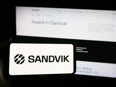 Stuttgart, Almanya - 08-15-2024: İsveçli mühendislik şirketi Sandvik AB 'nin logosunun bulunduğu akıllı telefon sahibi kişi web sitesi önünde. Telefon ekranına odaklan.