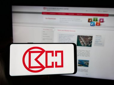 Stuttgart, Germany - 08-16-2024: Person holding smartphone with logo of Hong Kong company CK Hutchison Holdings Limited in front of website. Focus on phone display. clipart