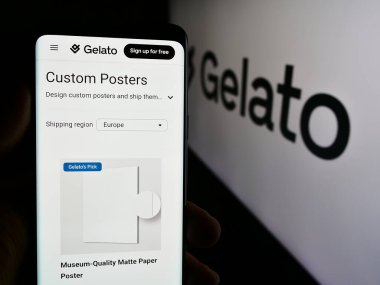 Stuttgart, Almanya - 08-18-2024: Logo önünde Norveçli baskı şirketi Gelato ASA 'nın web sayfası ile akıllı telefon tutan kişi. Telefon ekranının merkezine odaklan.