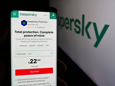 Stuttgart, Germany - 08-18-2024: Person holding smartphone with web page of Russian cybersecurity company AO Kaspersky Lab in front of logo. Focus on center of phone display. clipart