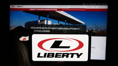 Stuttgart, Almanya - 08-18-2024: ABD 'li petrol hizmetleri şirketi Liberty Energy Inc.' in logosuyla cep telefonu sahibi kişi iş sayfasının önünde. Telefon ekranına odaklan.
