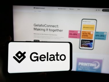 Stuttgart, Almanya - 08-18-2024: Web sitesi önünde Norveçli talep üzerine baskı şirketi Gelato ASA 'nın logosuna sahip kişi. Telefon ekranına odaklan.