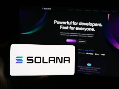 Stuttgart, Almanya - 08-18-2024: Web sitesi önünde elinde blok platform şirketi Solana 'nın logosu bulunan kişi. Telefon ekranına odaklan.