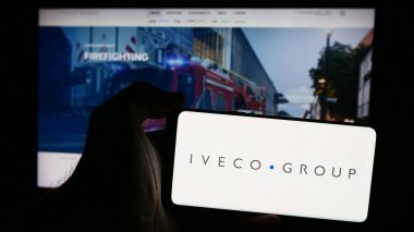 Stuttgart, Almanya - 08-18-2024: İtalyan ticari araç şirketi Iveco Group N.V. 'nin logosuna sahip akıllı telefon sahibi kişi web sitesinin önünde. Telefon ekranına odaklan.
