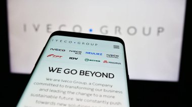 Stuttgart, Almanya - 08-18-2024: İtalyan ticari araç şirketi Iveco Group N.V. 'nin web sitesiyle birlikte iş logosu önünde cep telefonu. Telefon ekranının sol üst kısmına odaklan.