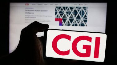 Stuttgart, Almanya - 08-18-2024: Kanadalı bilgi teknolojileri şirketi CGI Inc. 'nin logosuyla cep telefonu sahibi olan kişi iş sayfasının önünde. Telefon ekranına odaklan.