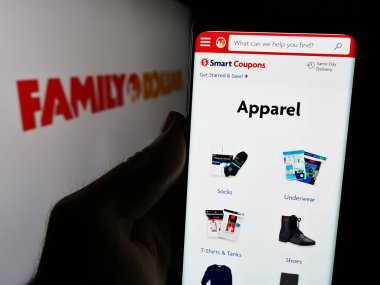 Stuttgart, Almanya - 08-19-2024: ABD 'li çeşitli mağaza şirketi Family Dollar Stores Inc.' in internet sayfası ile logo önünde cep telefonu tutan kişi. Telefon ekranının merkezine odaklan.