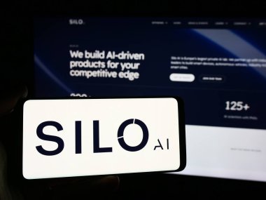 Stuttgart, Almanya - 08-19-2024: İnternet sitesi önünde üzerinde Fin yapay zeka şirketi Silo AI Oy 'un logosu bulunan akıllı telefon sahibi kişi. Telefon ekranına odaklan.