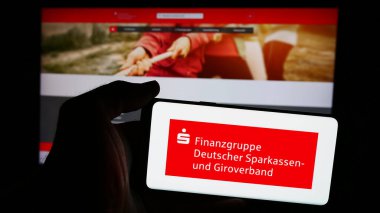 Stuttgart, Almanya - 08-19-2024: İnternet sayfası önünde Alman kamu bankacılık ağı Sparkassen-Finanzgruppe logosu bulunan cep telefonu sahibi kişi. Telefon ekranına odaklan.