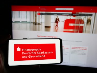 Stuttgart, Almanya - 08-19-2024: İnternet sitesi önünde Alman kamu bankacılık ağı Sparkassen-Finanzgruppe logosuna sahip kişi. Telefon ekranına odaklan.