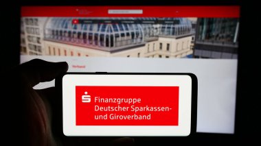 Stuttgart, Almanya - 08-19-2024: İnternet sayfası önünde Alman kamu bankacılık ağı Sparkassen-Finanzgruppe logosuna sahip cep telefonu sahibi kişi. Telefon ekranına odaklan.