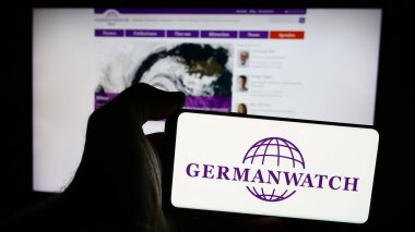 Stuttgart, Germany - 08-19-2024: Person holding mobile phone with logo of German non-governmental organisation Germanwatch e.V. in front of web page. Focus on phone display. clipart