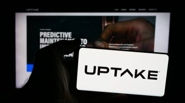 Stuttgart, Almanya - 08-19-2024: Web sitesi önünde ABD 'li AI şirketi Uptake Technologies Inc.' in logosuna sahip kişi. Telefon ekranına odaklan.