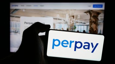 Stuttgart, Almanya - 08-19-2024: Amerikan finans hizmetleri şirketi Perpay Inc. 'in logosuyla cep telefonu sahibi kişi iş sayfasının önünde. Telefon ekranına odaklan.