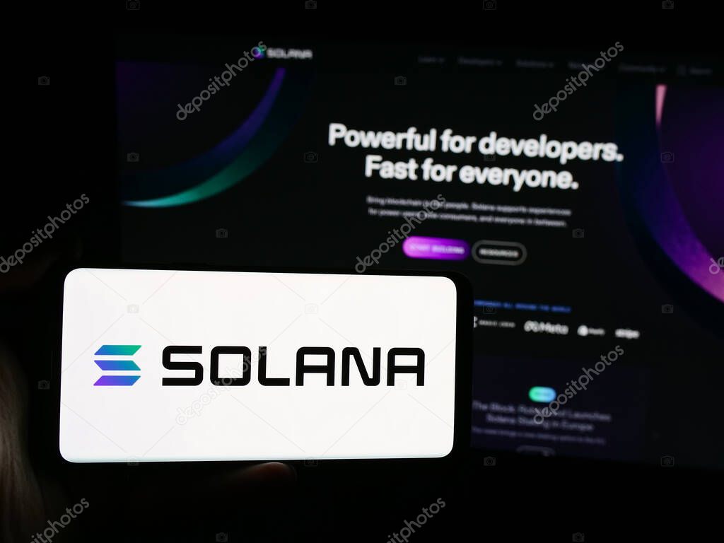 Stuttgart, Germany - 08-18-2024: Person holding smartphone with logo of blockchain platform company Solana in front of website. Focus on phone display.