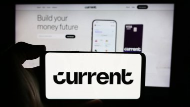 Stuttgart, Almanya - 08-19-2024: İş sayfası önünde ABD 'li fintech şirketi Current' in (Finco Services Inc.) logosuyla cep telefonu tutan kişi. Telefon ekranına odaklan.
