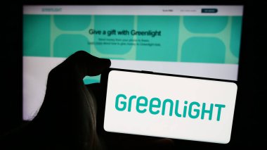 Stuttgart, Almanya - 08-19-2024: İnternet sayfası önünde ABD 'li fintech şirketi Greenlight Financial Technology Inc.' in logosuna sahip cep telefonu sahibi kişi. Telefon ekranına odaklan.