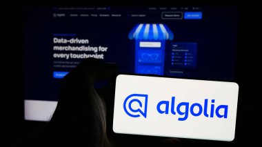 Stuttgart, Almanya - 08-19-2024: İçinde ai arama motoru şirketi Algolia Inc. 'in logosu olan cep telefonu sahibi kişi iş sayfasının önünde. Telefon ekranına odaklan.