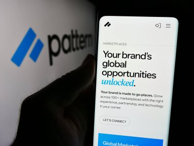 Stuttgart, Almanya - 08-19-2024: Logo önünde ABD 'li e-ticaret yazılım şirketi Patern Inc.' nin web sayfası ile cep telefonu tutan kişi. Telefon ekranının merkezine odaklan.