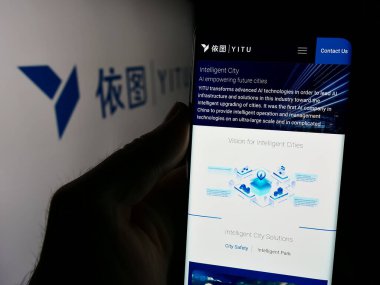 Stuttgart, Almanya - 08-19-2024: Çinli AI şirketi Shanghai YITU Technology Co. Ltd. logo önünde akıllı telefon sahibi kişi. Telefon ekranının merkezine odaklan.