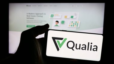 Stuttgart, Almanya - 08-19-2024: Amerikan emlak platformu şirketi Qualia Labs Inc. 'in logosunun bulunduğu cep telefonu web sayfasının önünde duruyor. Telefon ekranına odaklan.