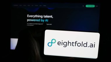 Stuttgart, Almanya - 08-19-2024: İnternet sitesi önünde ABD 'li yetenek istihbarat şirketi Eightfold AI Inc.' in logosuna sahip kişi. Telefon ekranına odaklan.
