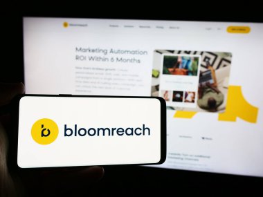 Stuttgart, Almanya - 08-19-2024: İnternet sayfası önünde üzerinde Amerikan e-ticaret platformu şirketi Bloomreach Inc. 'in logosu bulunan cep telefonu sahibi kişi. Telefon ekranına odaklan.