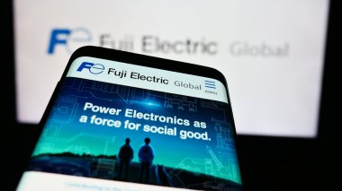 Stuttgart, Almanya - 08-20-2024: Japon firması Fuji Electric Co. Ltd. nin internet sitesi ile birlikte ticari logonun önünde akıllı telefon. Telefon ekranının sol üst kısmına odaklan.