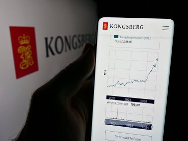 Stuttgart, Almanya - 08-20-2024: Logo önünde Norveçli firma Kongsberg Gruppen ASA 'nın web sayfası ile cep telefonu tutan kişi. Telefon ekranının merkezine odaklan.