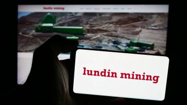Stuttgart, Almanya - 08-20-2024: Kanadalı Lundin Madencilik Şirketi 'nin logosu olan cep telefonu sahibi kişi iş sayfasının önünde. Telefon ekranına odaklan.