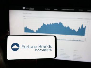 Stuttgart, Almanya - 08-20-2024: İnternet sayfası önünde ABD 'li ev güvenlik şirketi Fortune Mards Innovations Inc.' in logosuna sahip cep telefonu sahibi kişi. Telefon ekranına odaklan.