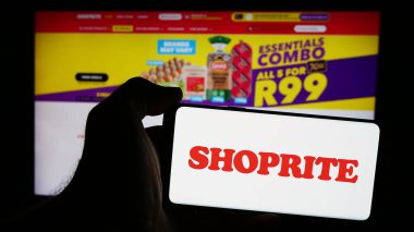 Stuttgart, Almanya - 08-21-2024: İnternet sayfası önünde Güney Afrikalı süpermarket şirketi Shoprite Holding Ltd. 'nin logosuyla cep telefonu tutan kişi. Telefon ekranına odaklan.