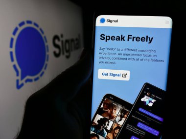 Stuttgart, Almanya - 08-21-2024: İnternet sitesi önünde açık kaynaklı anlık mesajlaşma servisi sinyali logosuna sahip kişi. Telefon ekranına odaklan.