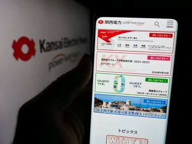 Stuttgart, Almanya - 08-21-2024: Japon şirketi Kansai Electric Power Co. Inc. (KEPCO) 'nun logolu web sayfası ile cep telefonu tutan kişi. Telefon ekranının merkezine odaklan.