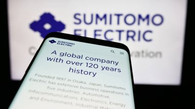Stuttgart, Almanya - 08-21-2024: Japon şirketi Sumitomo Electric Industries Ltd. 'nin web sitesi ile birlikte ticari logo önünde akıllı telefon. Telefon ekranının sol üst kısmına odaklan.