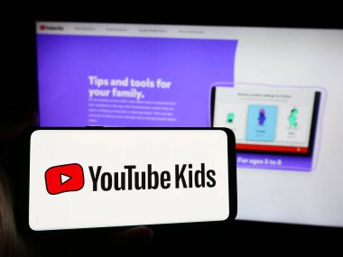 Stuttgart, Almanya - 08-21-2024: İnternet sitesi önünde ABD 'li video paylaşım platformu şirketi YouTube Kids' in logosuna sahip kişi. Telefon ekranına odaklan.