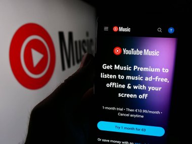 Stuttgart, Almanya - 08-21-2024: İş logosu önünde ABD müzik yayın servisi YouTube Müzik web sayfası ile cep telefonu tutan kişi. Telefon ekranının merkezine odaklan.