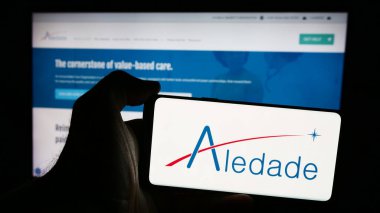 Stuttgart, Almanya - 08-22-2024: Web sitesi önünde ABD 'li birincil bakım ağı şirketi Aledade Inc.' in logosuna sahip kişi. Telefon ekranına odaklan.