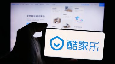 Stuttgart, Almanya - 08-24-2024: Çinli çevrimiçi bilgi şirketi Kujiale 'in logosunun bulunduğu akıllı telefonu web sitesinin önünde tutan kişi. Telefon ekranına odaklan.