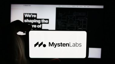 Stuttgart, Almanya - 08-24-2024: Web3 altyapı şirketi Mysten Labs Inc. 'in logosuna sahip cep telefonu sahibi kişi iş sayfasının önünde. Telefon ekranına odaklan.